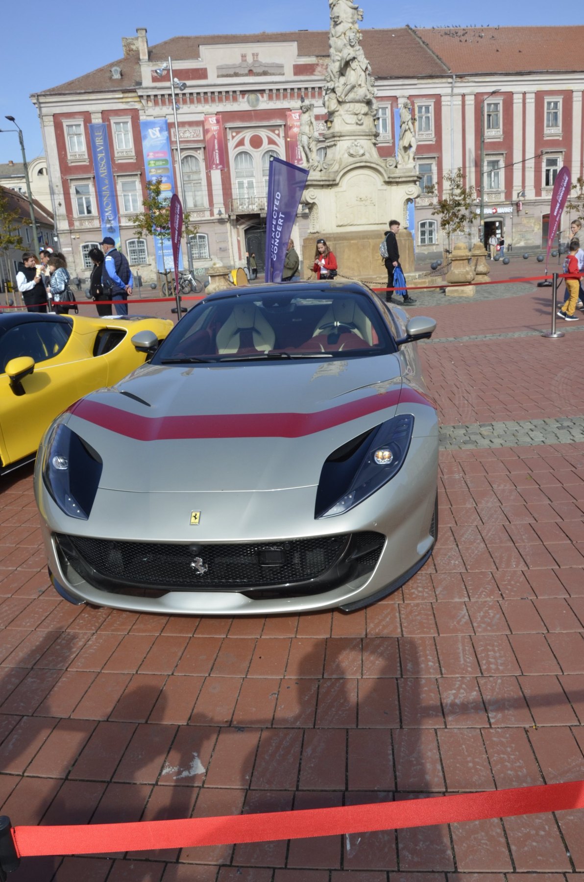 Ferrari argintiu cu dungă roșie, alături de un Ferrari galben