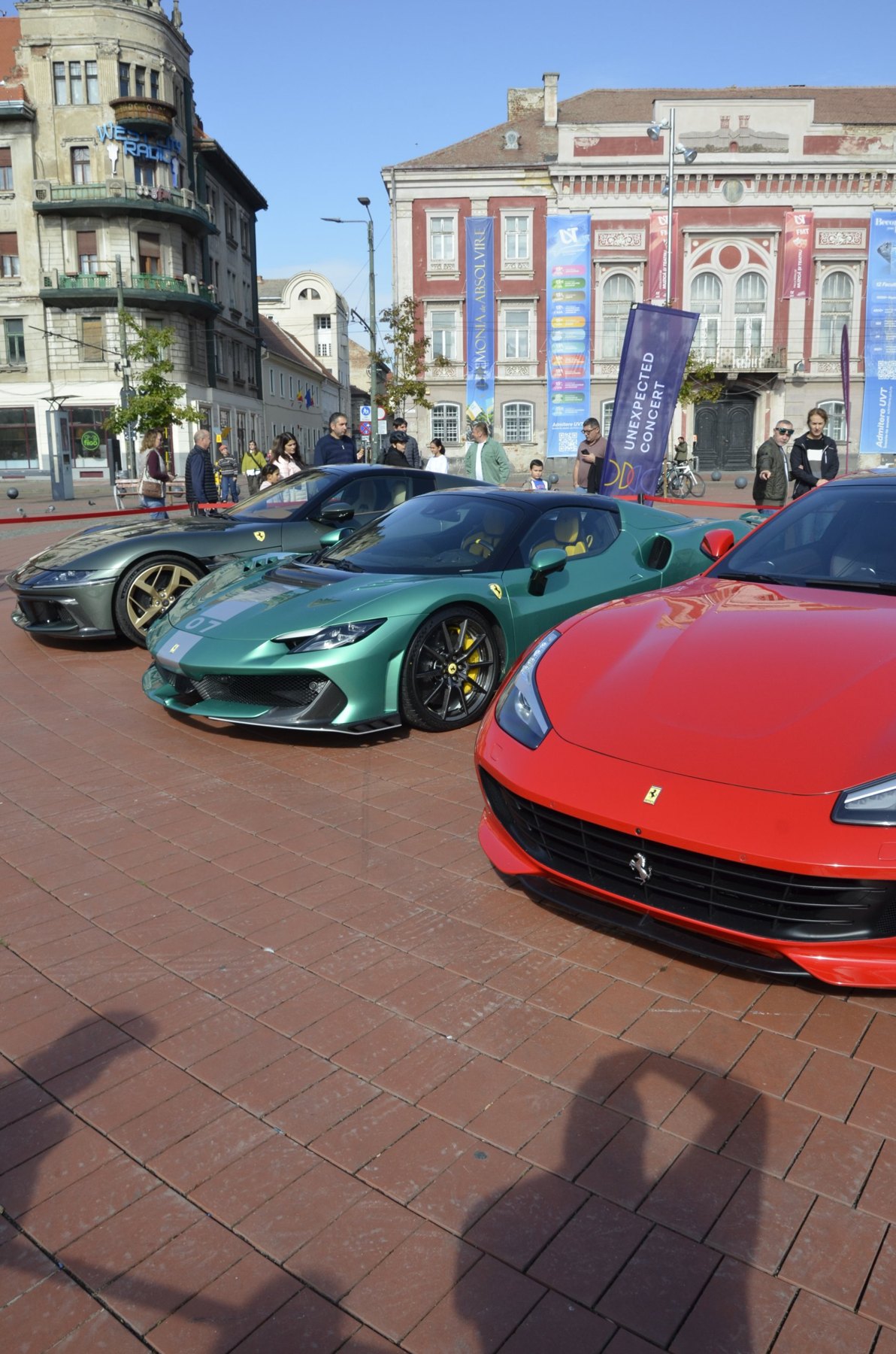 Ferrari verde, Ferrari roșu și un Ferrari gri, expuse alături