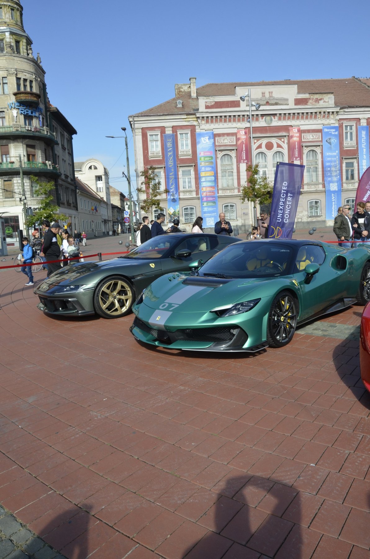 Ferrari verde, din față, cu vizitatori în fundal