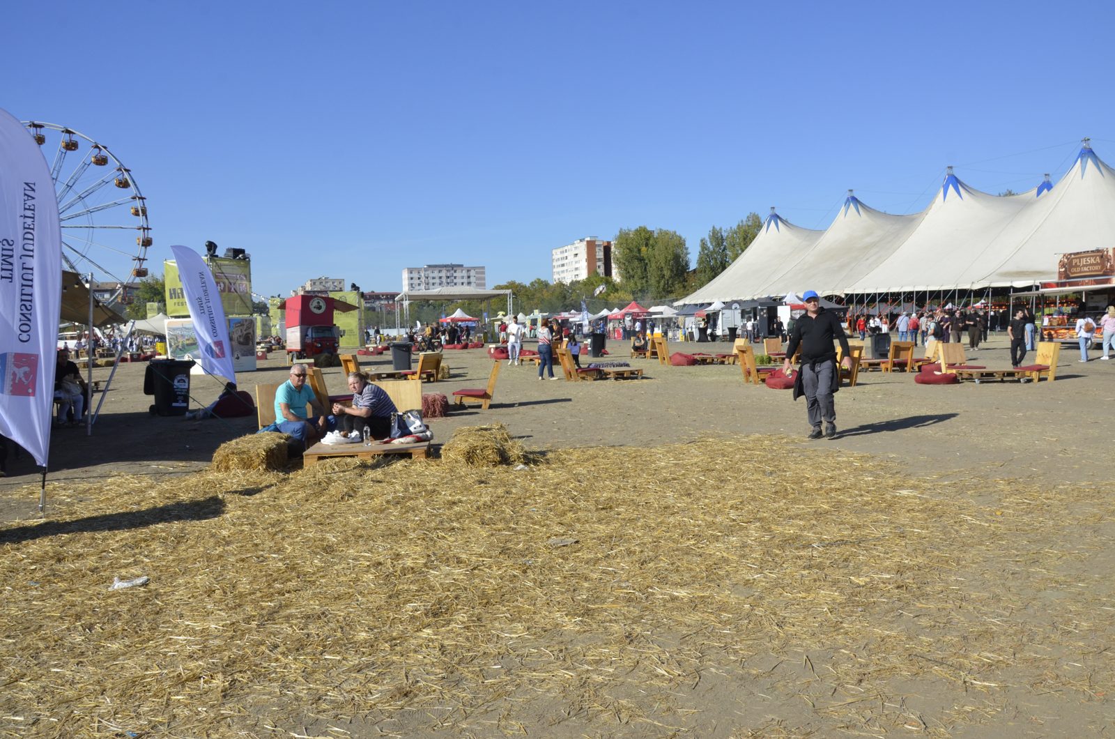 Zona de relaxare cu paie, paleți și steaguri Consiliul Județean Timiș; în dreapta, cortul mare