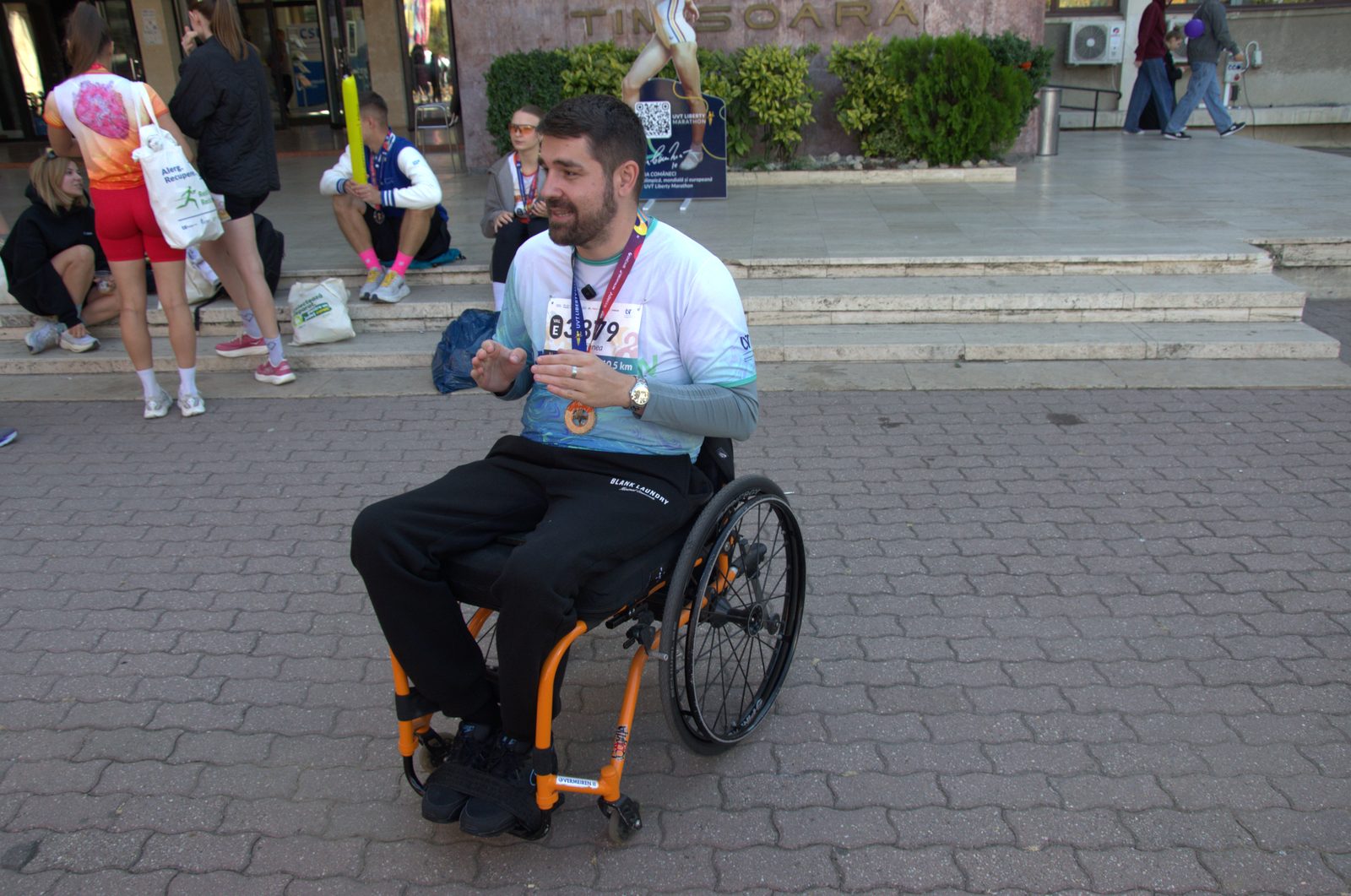 Mihnea Vilceanu, in scaun cu rotile, cu numarul de concurs si medalia UVT Liberty Marathon 2026