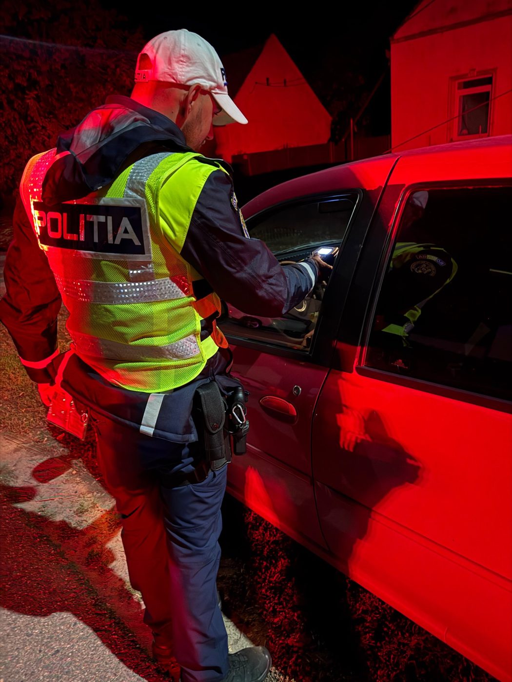 Polițist rutier testează un șofer cu aparatul etilotest, noaptea, în Timișoara