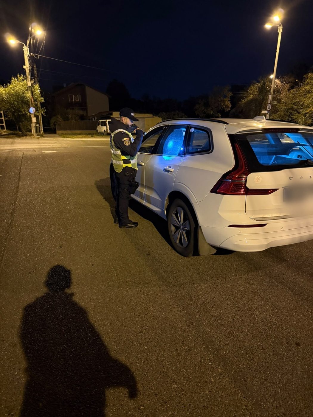 Polițist care verifică un autoturism alb