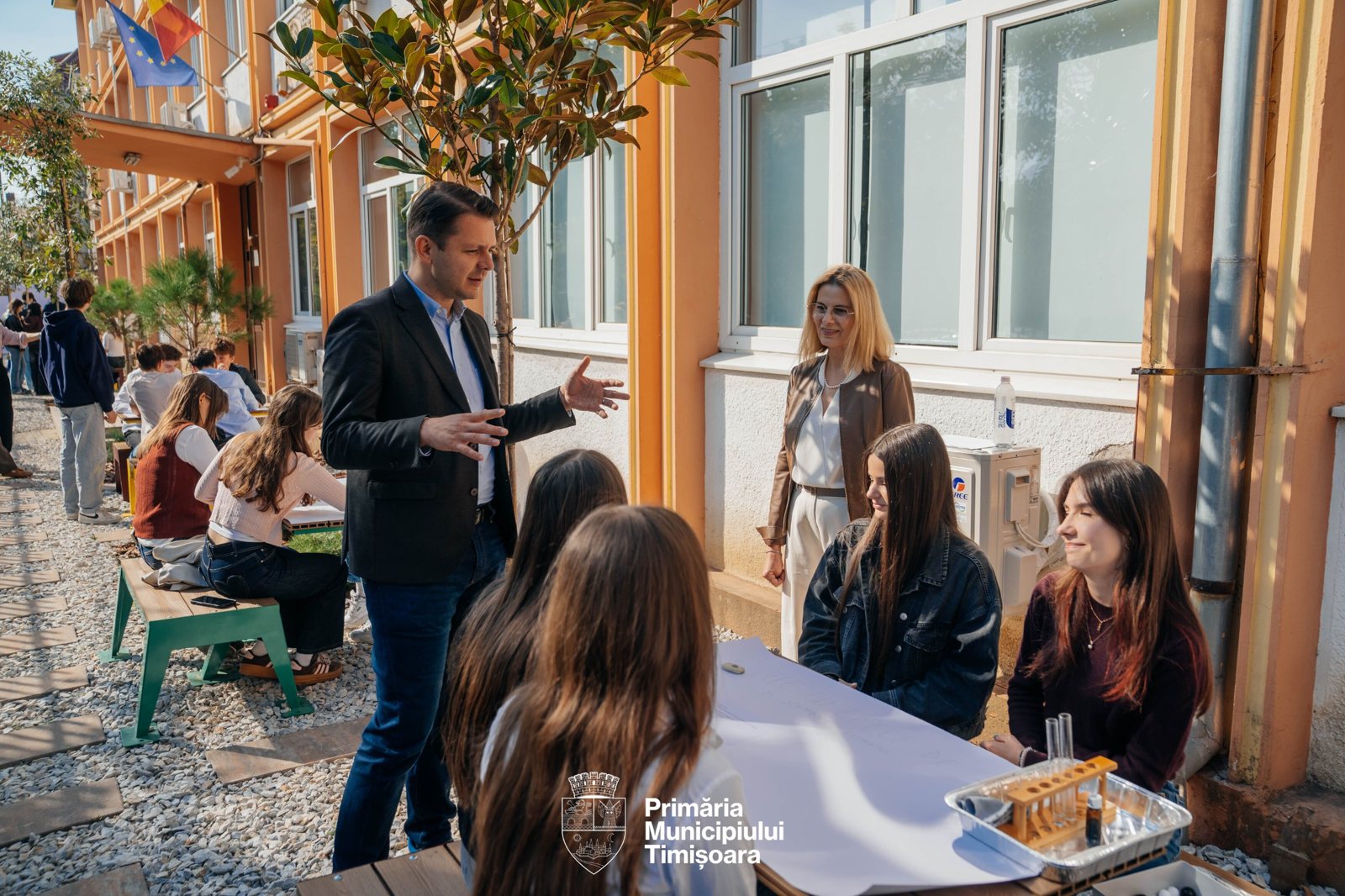 Discuție cu elevii la una dintre mesele din curte