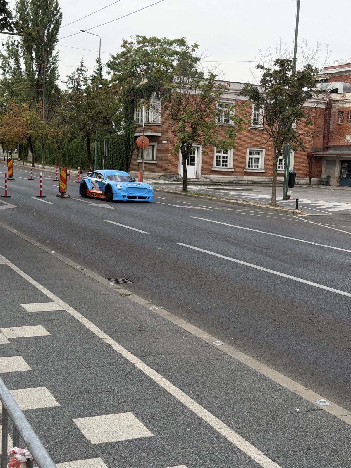 Mașină de curse pe traseu, văzută din același punct de filmare, lângă Primărie