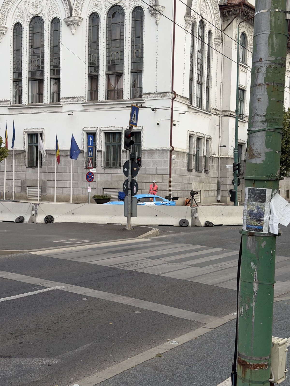 Mașină de curse portocalie, pe traseul delimitat cu conuri de avertizare