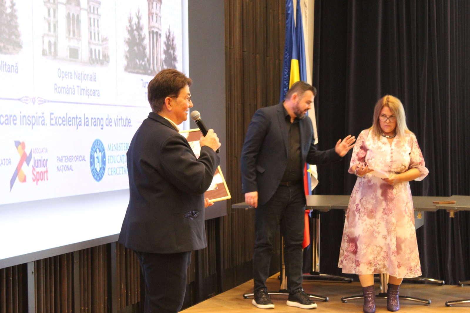 Moment de pe scena galei, cu ecranul proiectului și logo-urile organizatorilor