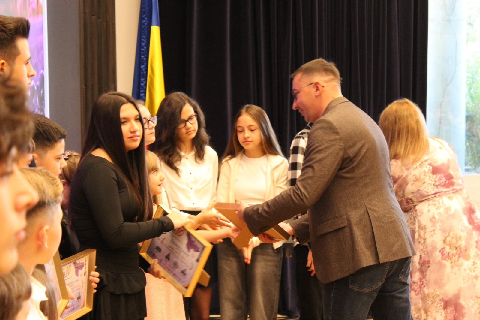 Elevi premiați, cu diplomele în mână, pe scena galei