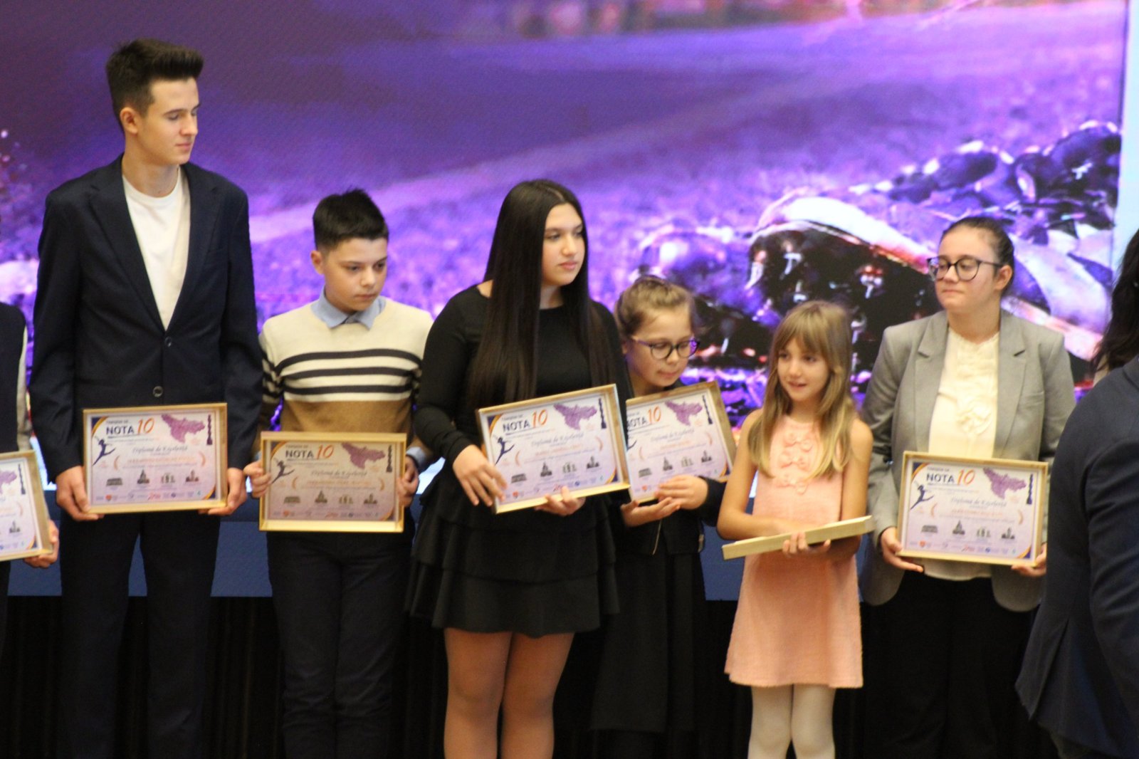 Elevi cu diplomele de excelenta Timiseni de Nota 10 in mana, pe scena galei