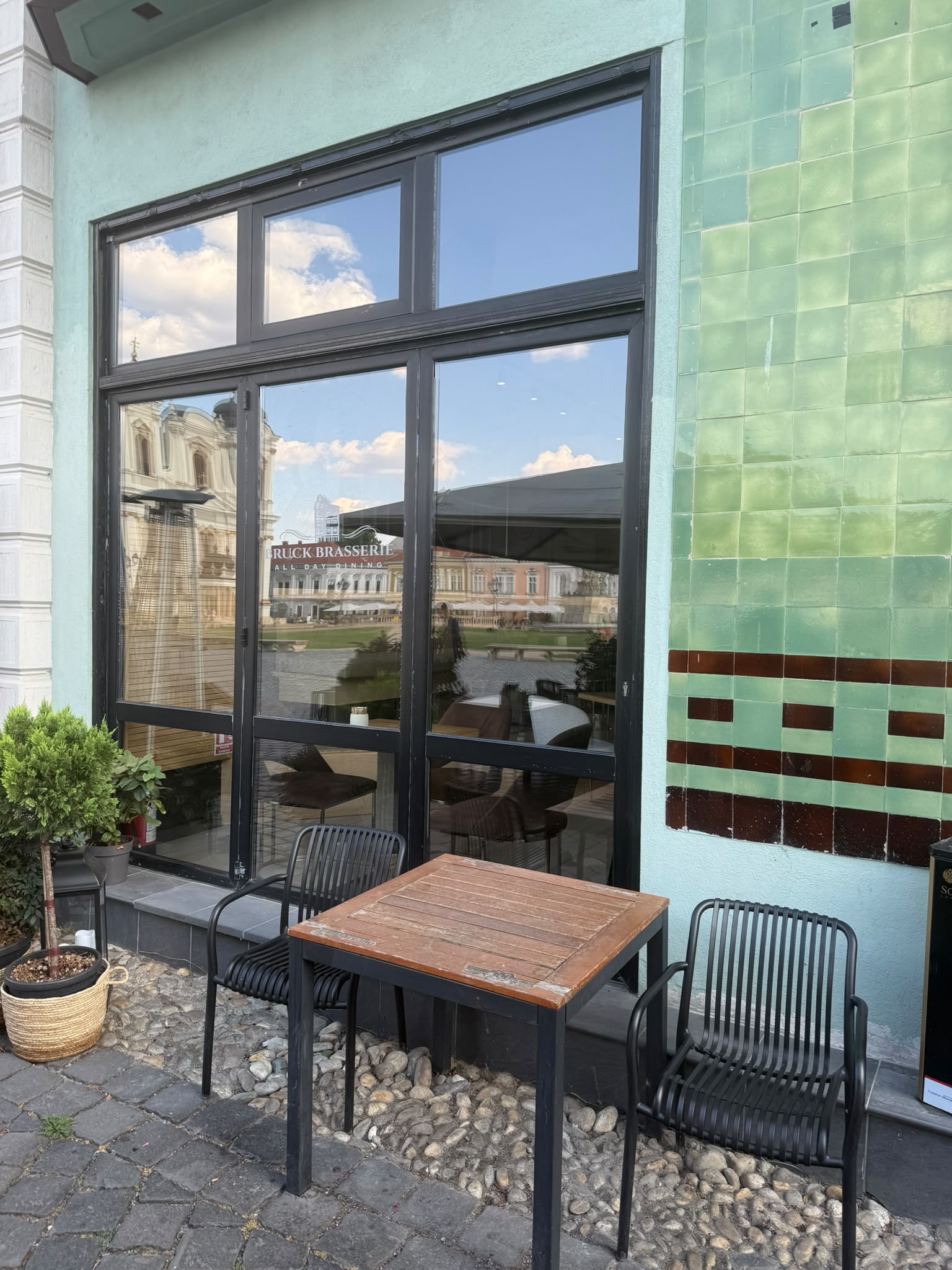 Terasa Bruck Brasserie Timișoara, cu vitrina reflectând piața din centru