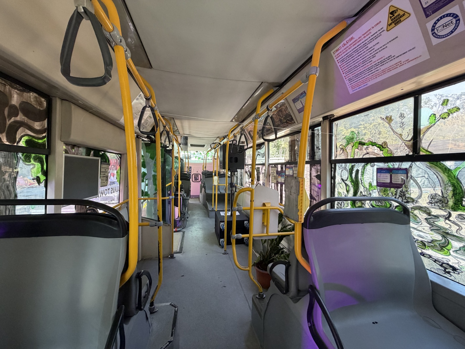 Interiorul autobuzului transformat în instalație artistică, cu geamuri pictate