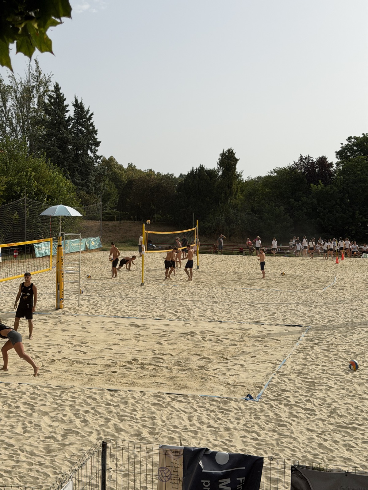 Grup de juniori la joc, urmăriți de spectatori pe margine