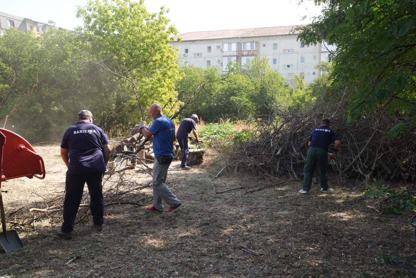 Echipe de muncitori curăță vegetația și resturile rezultate din desființarea construcțiilor ilegale