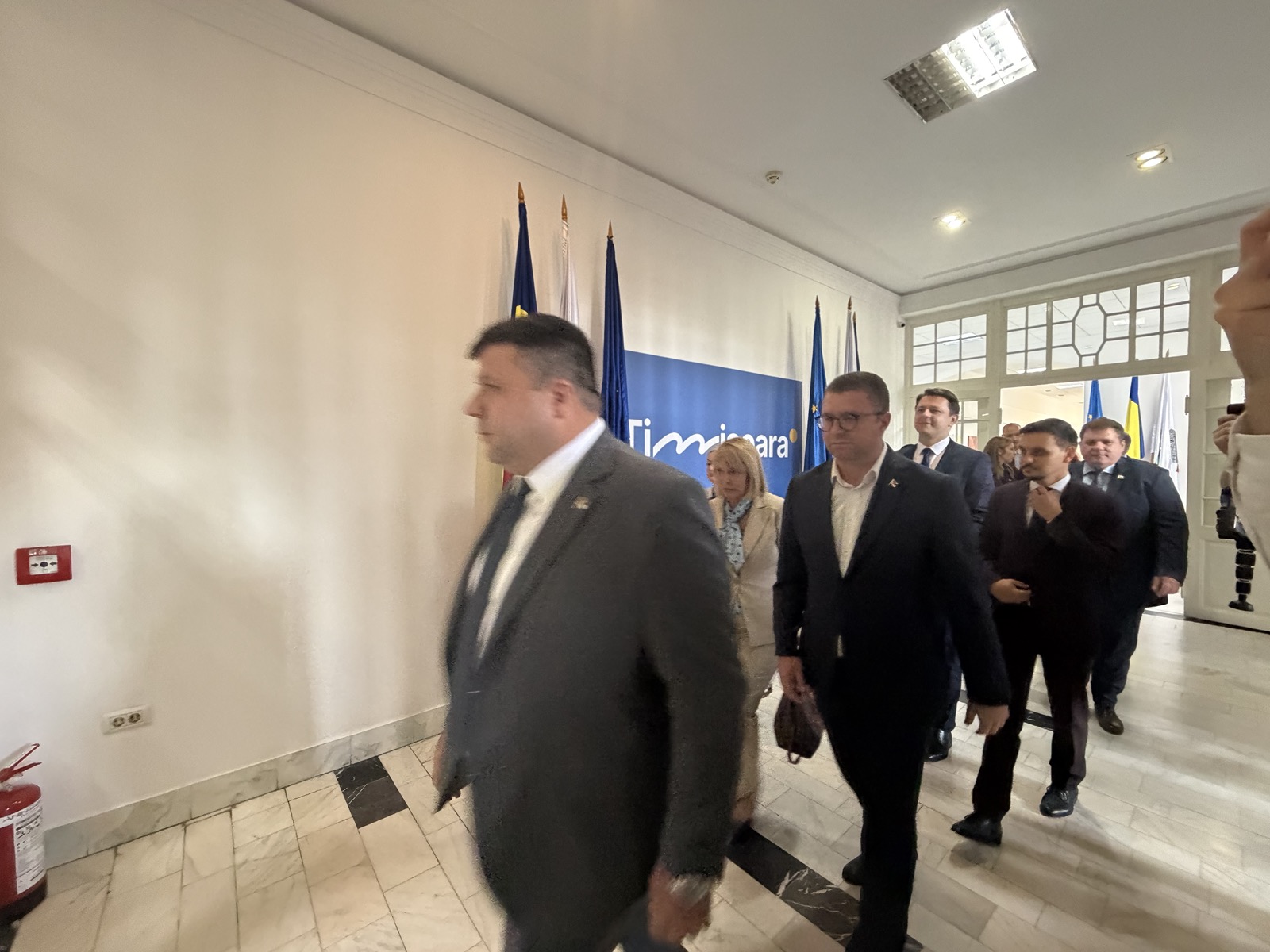 Delegațiile intră în sala de consiliu, sub bannerul Municipiul Timișoara