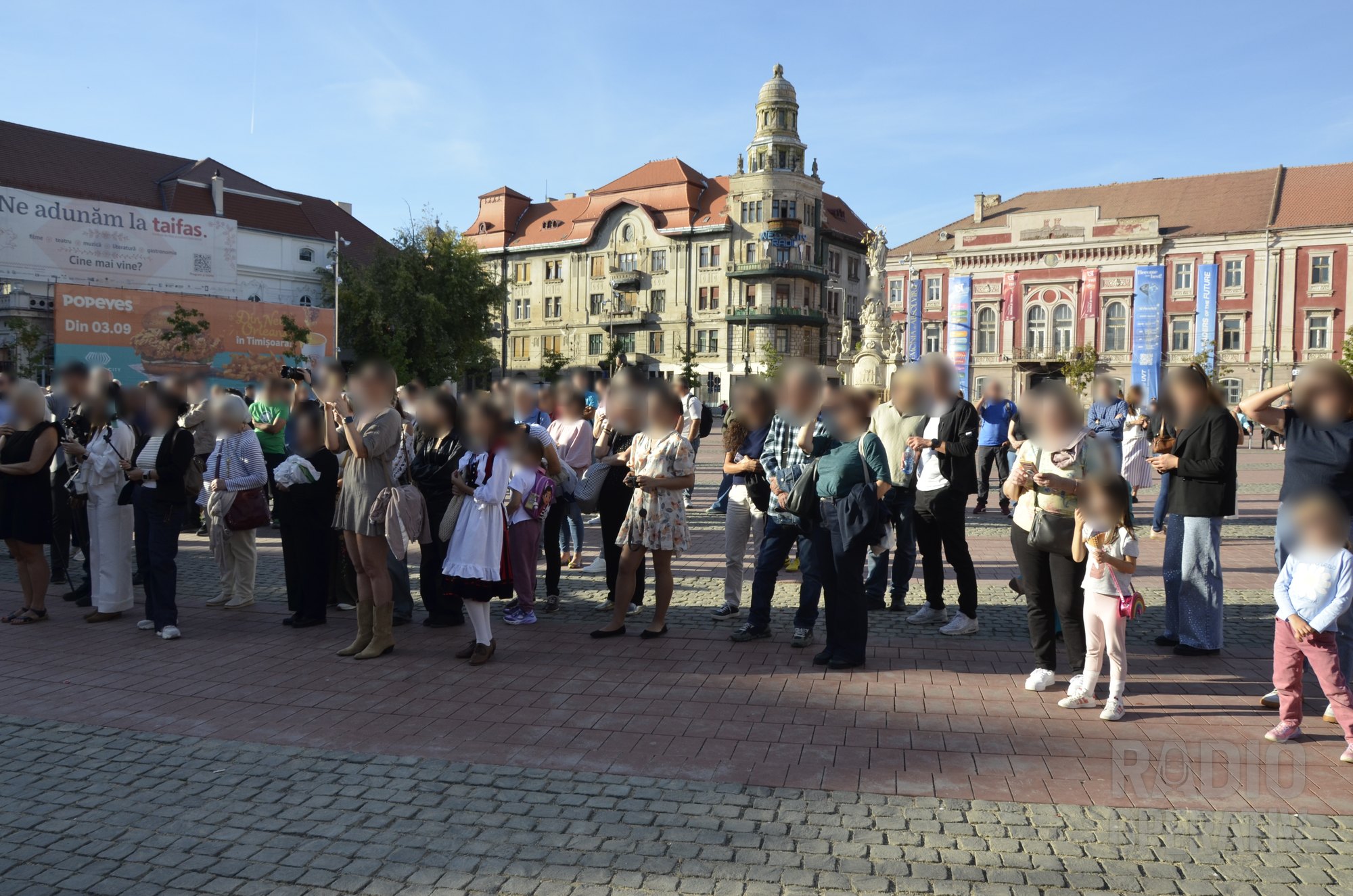 Public în fața scenei; în dreapta cadrului se vede Statuia Sfintei Treimi