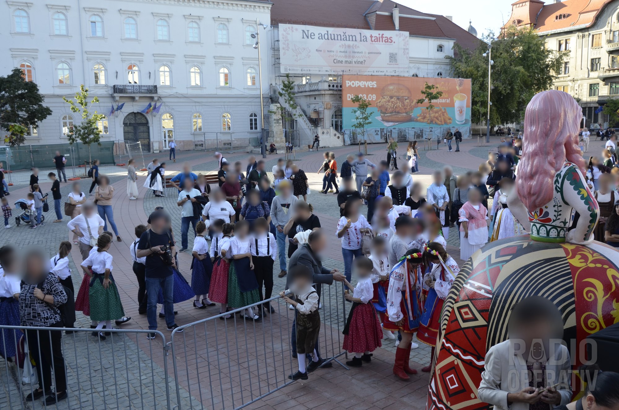 Copii în costume populare, adunați la bariera din apropierea scenei