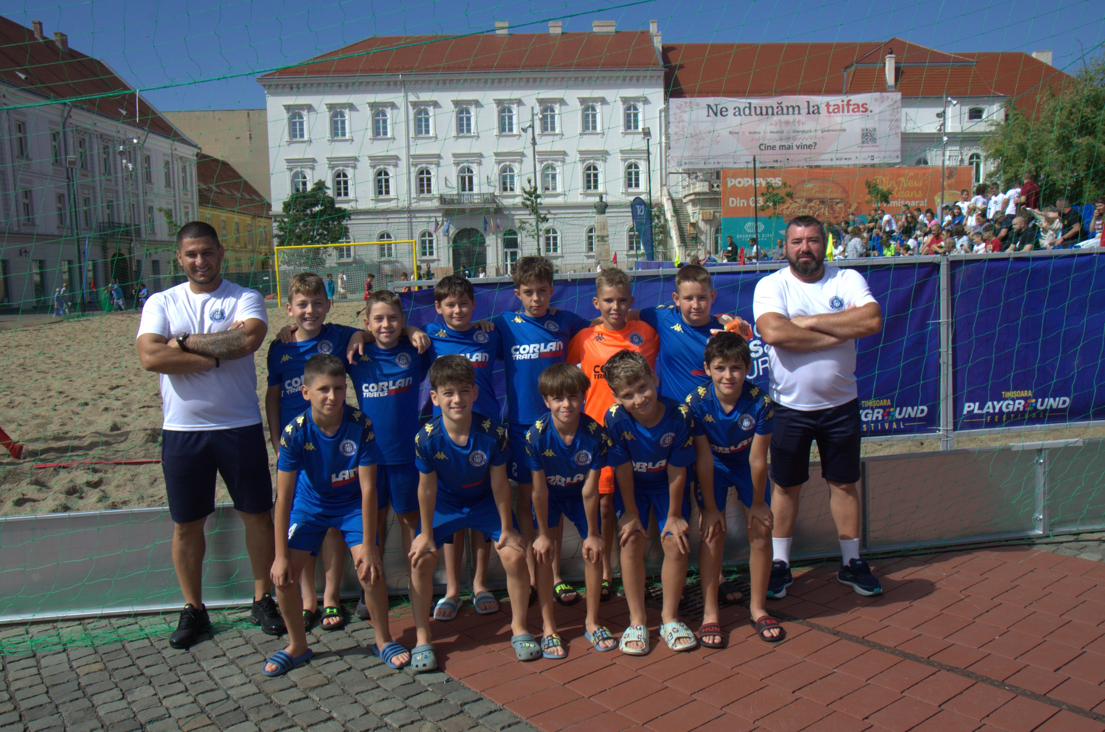Echipă de juniori a Asociației Sportive Tim Star, în echipament albastru, alături de antrenori