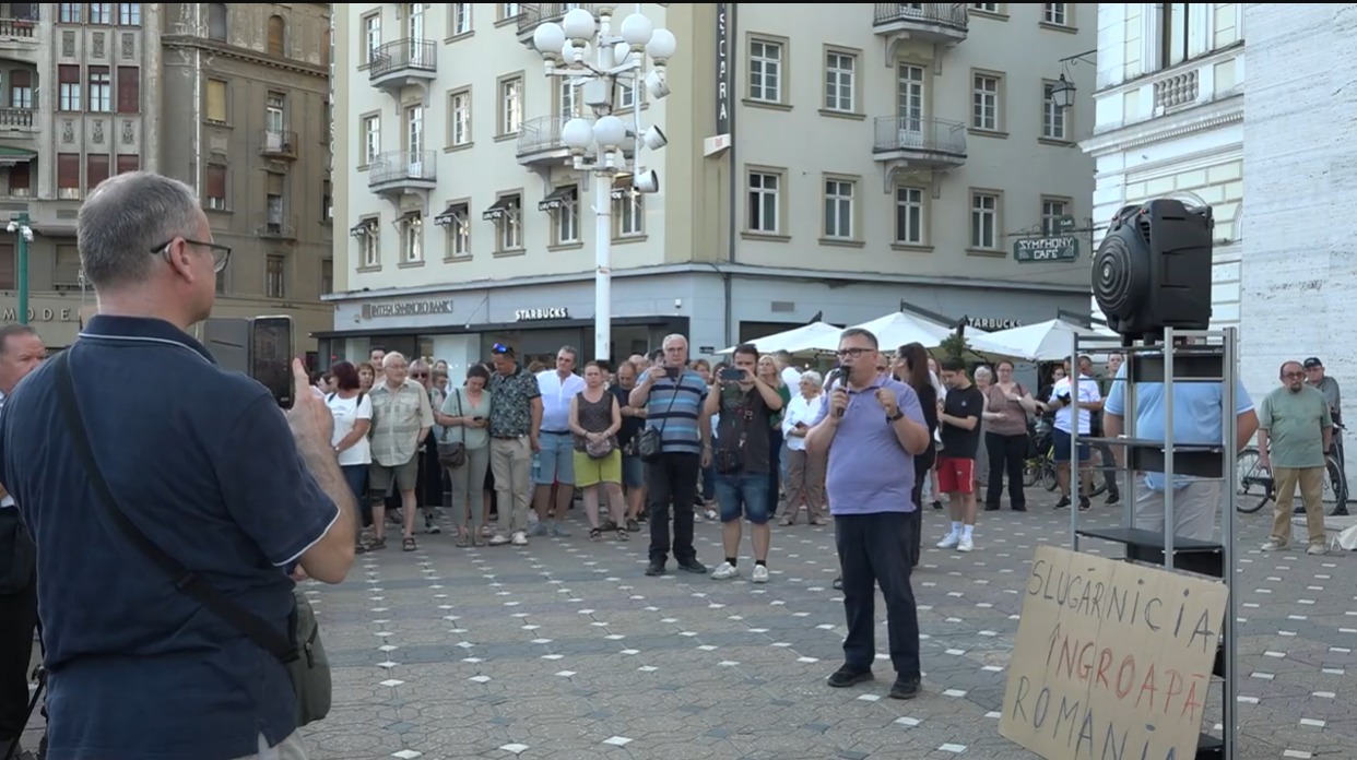 Multime adunata in Piata Operei din Timisoara, un barbat vorbeste la microfon