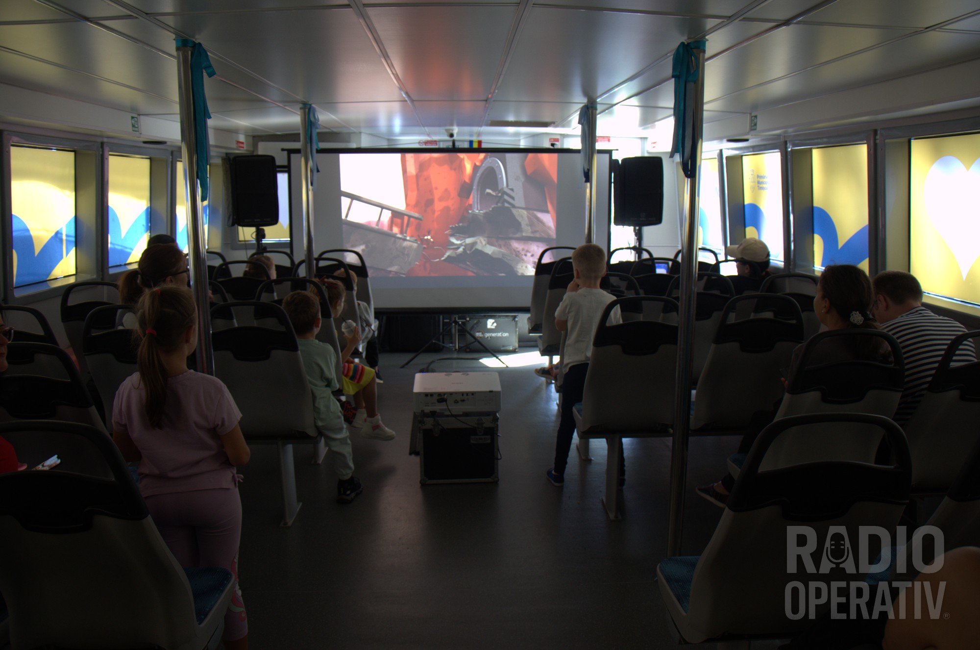 Copii urmărind desene animate în vaporetto, la Bridge Kids