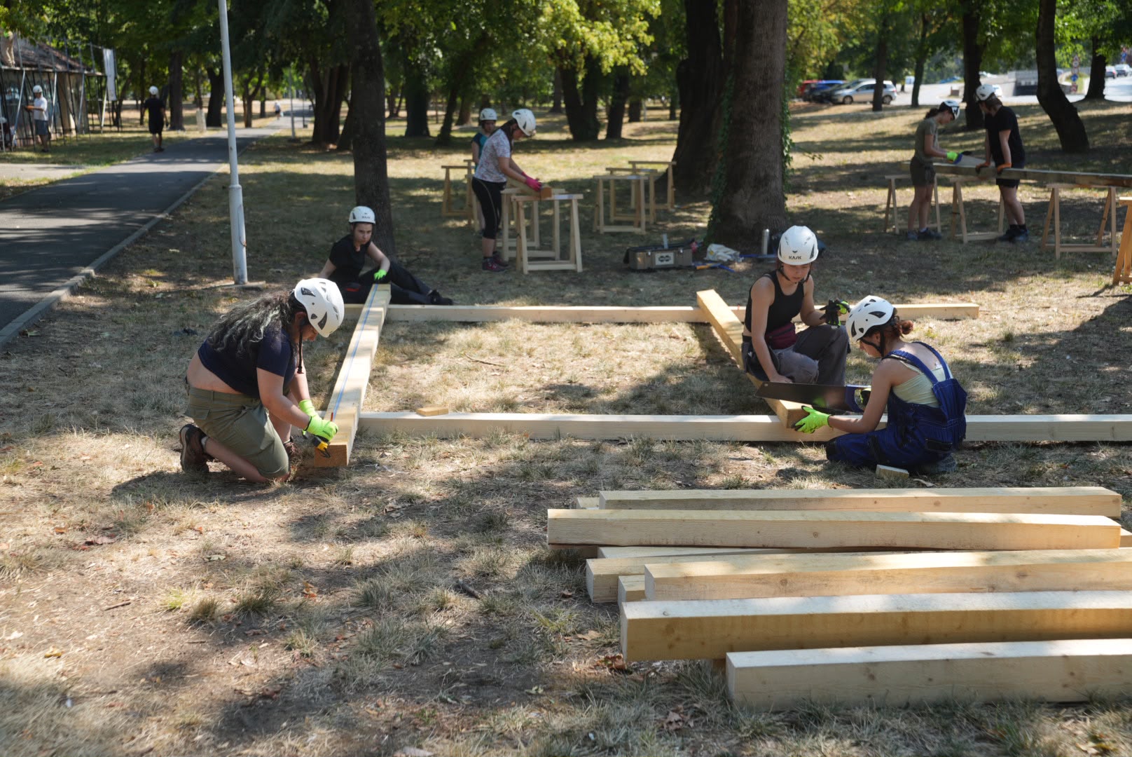 Voluntari pregătesc grinzile de lemn pentru șarpanta Uszodei