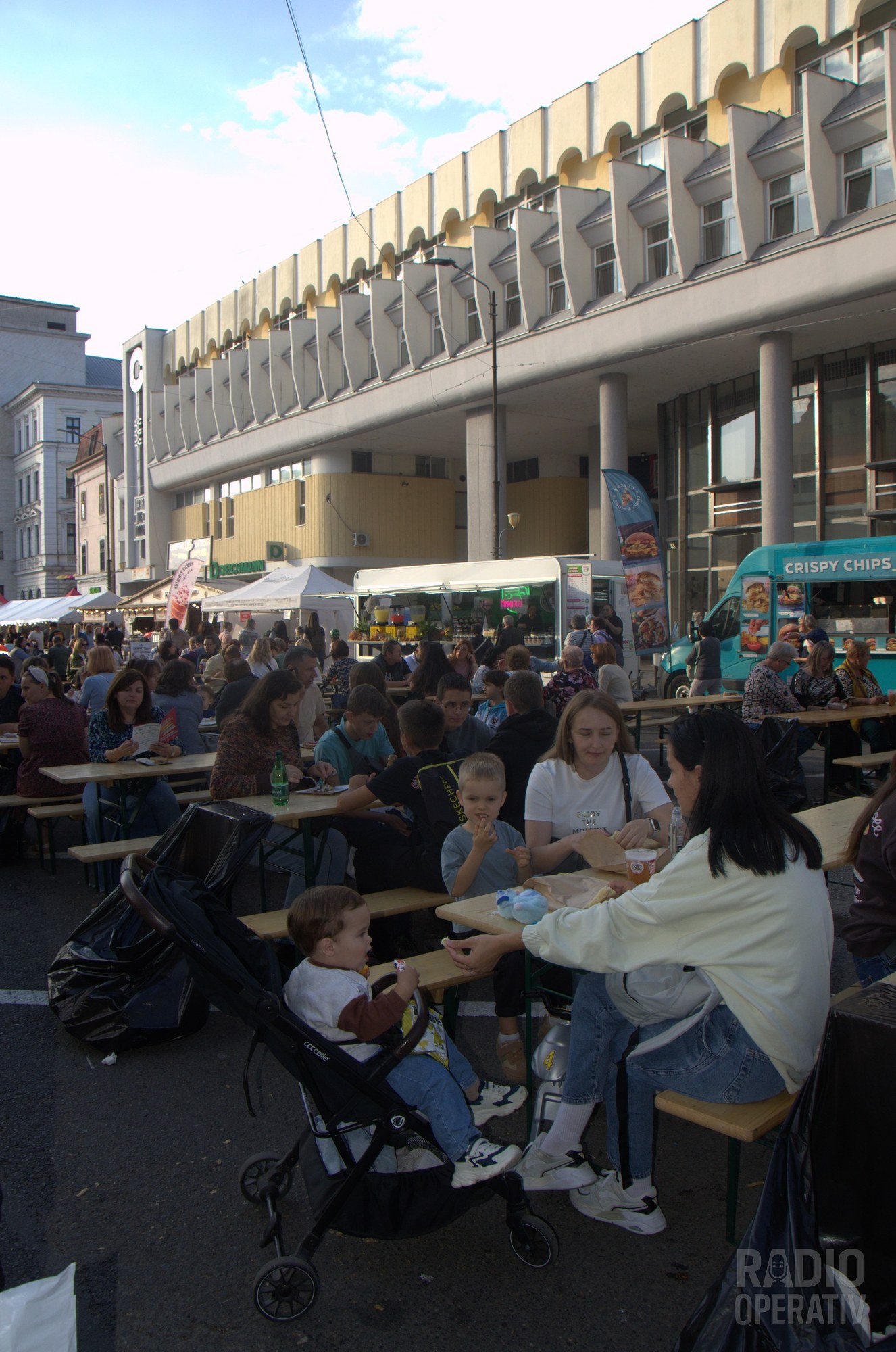 Zona de mese, cu food truck-uri pe fundal